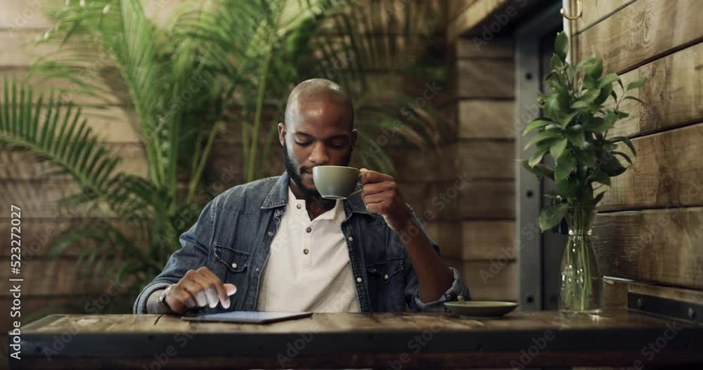 Poster handsome young man drinking coffee and working on a digital tablet at a cafe. serious casual man bro