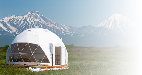 Glamping house and volcano, rural landscape, tent houses in Kamchatka peninsula. Selective focus.