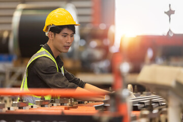 Asian male workers wear red helmet working check up iron production manufacturing in factory....
