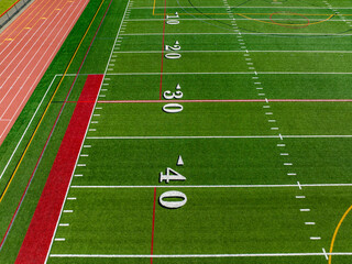 Aerial image of a typical synthetic turf football field 40 yard line in white. 	