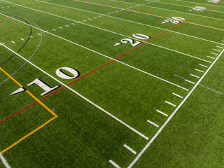 Obraz premium Aerial image of a typical synthetic turf football field 10 yard line in white. 