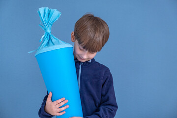  Child holding traditional German candy cone on the first school day. Boy with a sweet bag....