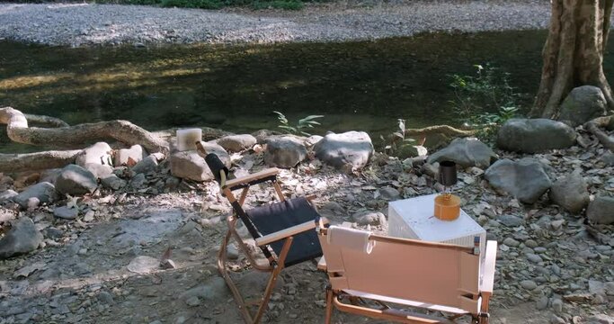 Camping tent empty chair in tree forest river with equipment