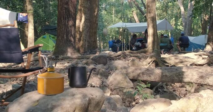 Camping tent empty chair in tree forest river with equipment