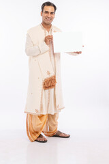 Portrait of bengali man in traditional clothing holding blank placard on occasion of durga puja...