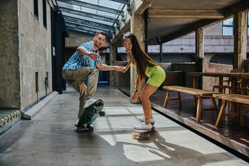 Couple playing skateboard together outdoor.