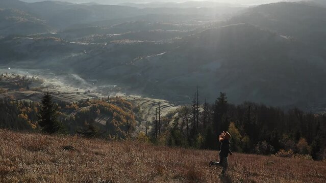 Side view of happy woman running an in front of mountains during sunrse