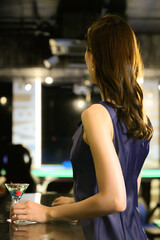 バーカウンターで待ち合わせしている女性　顔無し