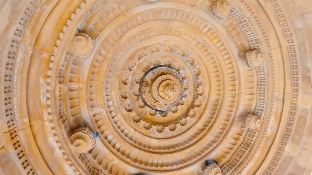 4K shot of the carved dome of the cenotaphs from below at Bada Bagh in Jaisalmer, Rajasthan, India. Ancient carvings on the roof of the dome made out of sandstone. Carved ceiling at Bada bagh cenotaph