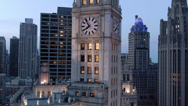Aerial Backward Shot Of Clock On Corporate Headquarters In City During Dusk - Chicago, Illinois