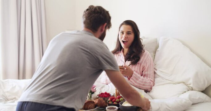 Valentines surprise, birthday or womans day breakfast in bed by a romantic husband for his wife with cute flowers to celebrate together at home. Sweet, in love and loving man serving his lady food