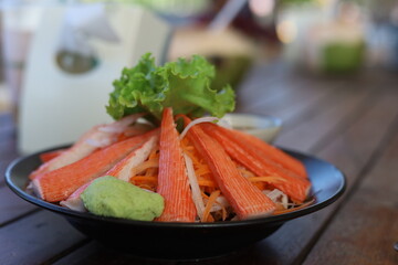 crab sticks with wasabi in black plate