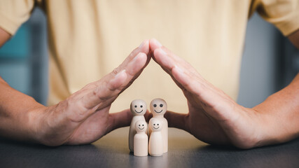 Father put his hand next to a wooden block to show protection for the family. and support and help advice The concept of family relationships to be connected to safety loving kindness - obrazy, fototapety, plakaty