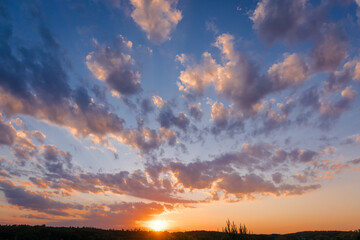 Beautiful sunset sky above clouds with dramatic light. Sunset sky with multicolor clouds. Dramatic twilight sky background