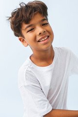 Happy carefree Indian boy against bluish white background