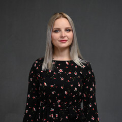 Portrait of a beautiful young blonde woman with long straight hair on a gray background