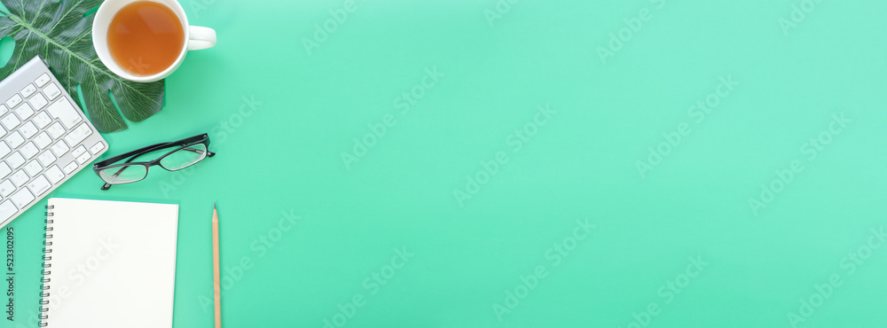Poster Flat lay of top view desk work table with Coffee computer notebook and pencil work space in minimal green color spring tone concept includes copyspace for add text or graphic