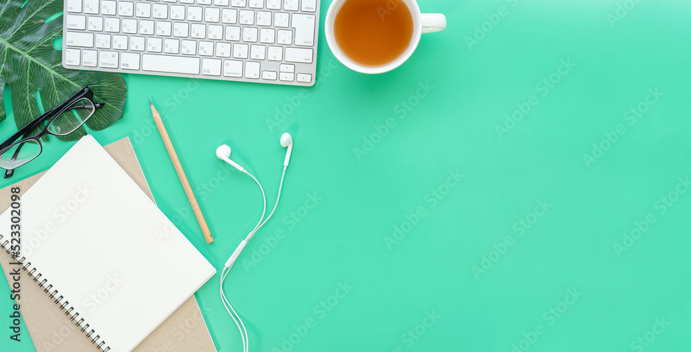 Poster Flat lay of top view desk work table with Coffee computer notebook and pencil work space in minimal green color spring tone concept includes copyspace for add text or graphic