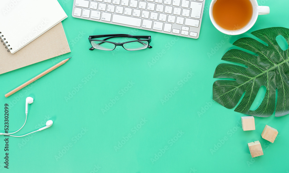 Poster Flat lay of top view desk work table with Coffee computer notebook and pencil work space in minimal green color spring tone concept includes copyspace for add text or graphic