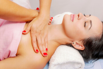 Young woman getting a massage at the spa. A woman enjoys a relaxing back massage in a beauty spa. Body care, skin care