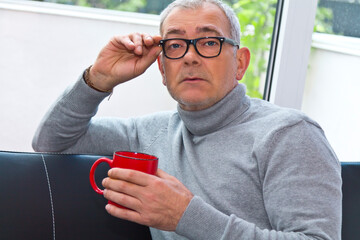 relaxed man on the sofa with a cup of coffee