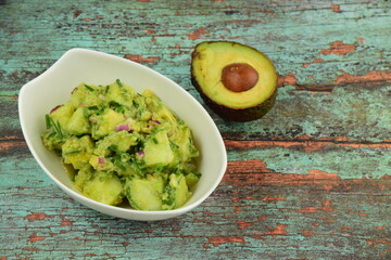 Homemade healthy avocado salad with cucumber, red onion, parsley and avocado lime dressing