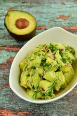 Homemade healthy avocado salad with cucumber, red onion, parsley and avocado lime dressing
