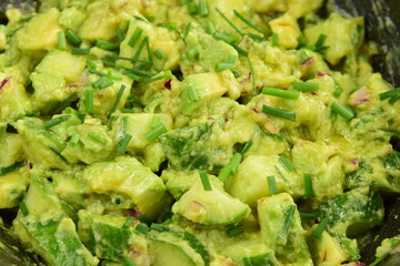 Homemade healthy avocado salad with cucumber, red onion, parsley and avocado lime dressing