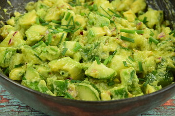 Homemade healthy avocado salad with cucumber, red onion, parsley and avocado lime dressing