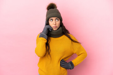 Young caucasian girl with winter hat isolated on purple background thinking an idea