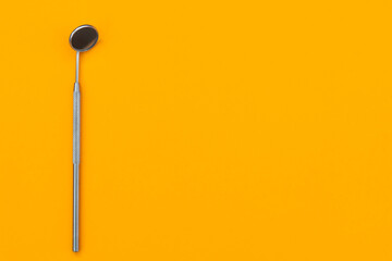 dental mirror on an orange background