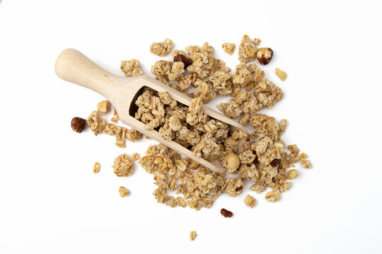 crunchy granola in wooden scoop isolated on white background