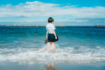 制服で海に立つ女性