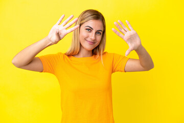 Blonde Uruguayan girl isolated on yellow background counting nine with fingers