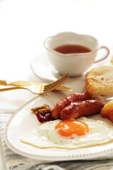 sausage and sunny side up fried egg served with cream cheese toast 