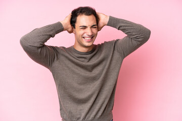 Young caucasian man isolated on pink background laughing