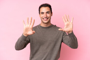 Young caucasian man isolated on pink background counting nine with fingers