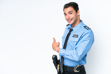 Young police caucasian man isolated on white background pointing back
