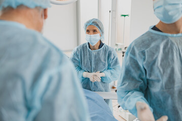 Professional surgical team working with a patient in an operation room of modern clinic
