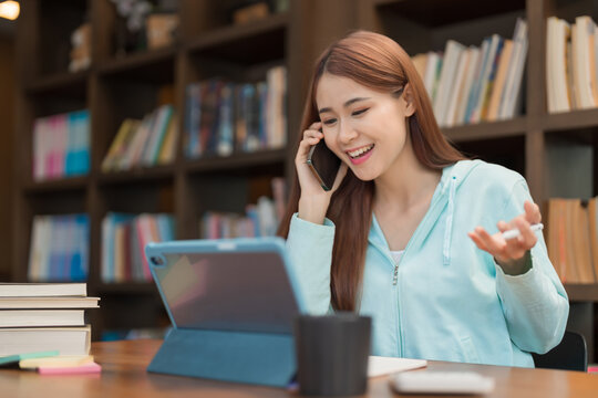 Education concept, Teenage girl talking on smartphone while watching video math tutorial on tablet
