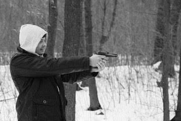 Fototapeta premium A man shooting by the pistol in the forest