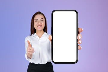 Fototapeta na wymiar Businesswoman with thumb up, phone empty display on purple background