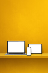 Laptop, mobile phone and digital tablet pc on yellow wall shelf. Vertical background