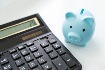 Piggy bank, calculator on white background and copy space