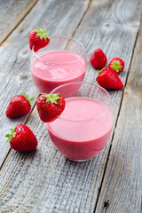 Traditionelle deutsche Erdbeere mit hausgemachtem Erdbeerquark serviert in einem Glas als close-up auf einem Holz Tablett