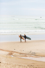 couple walking with surfboards