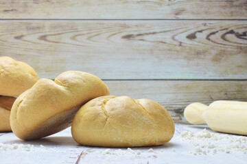 Small round loaves on light colored rustic table.