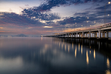 Obraz premium Sunrise shoot under the Penang Bridge. Penang bridges are crossings over the Penang Strait in Malaysia. They connect the area of Seberang Perai on the Malay peninsula with the island of Penang.