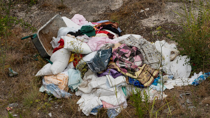 used old clothes thrown on the ground on the street. Environmental pollution
