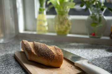 Bread on the chopping block in the kitchen with knife and flower
